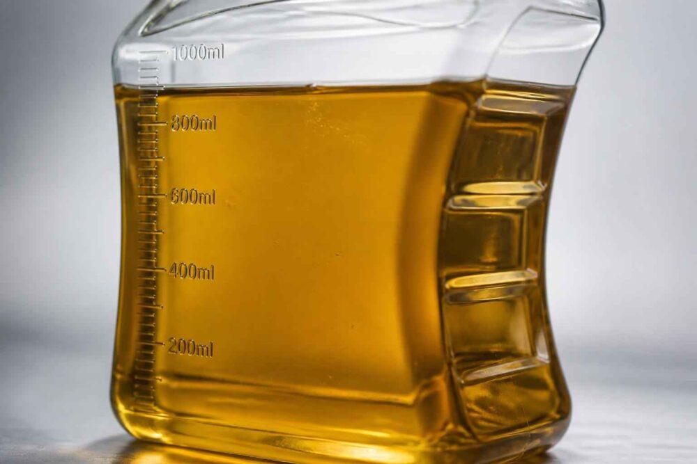 Szklany dzbanek miarowy wypełniony bursztynowym płynem do poziomu 800 ml