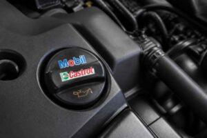 Korek wlewu oleju Mobil Castrol na osłonie silnika samochodowego