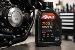 Butelka oleju Motul 7100 10W-40 ustawiona obok silnika motocyklowego