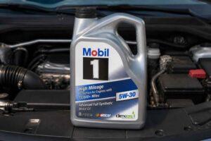 Kanister oleju Mobil 1 5W-30 ustawiony na silniku samochodu