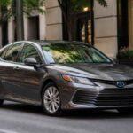 Szary Toyota Camry zaparkowany przy eleganckiej kamienicy w centrum miasta